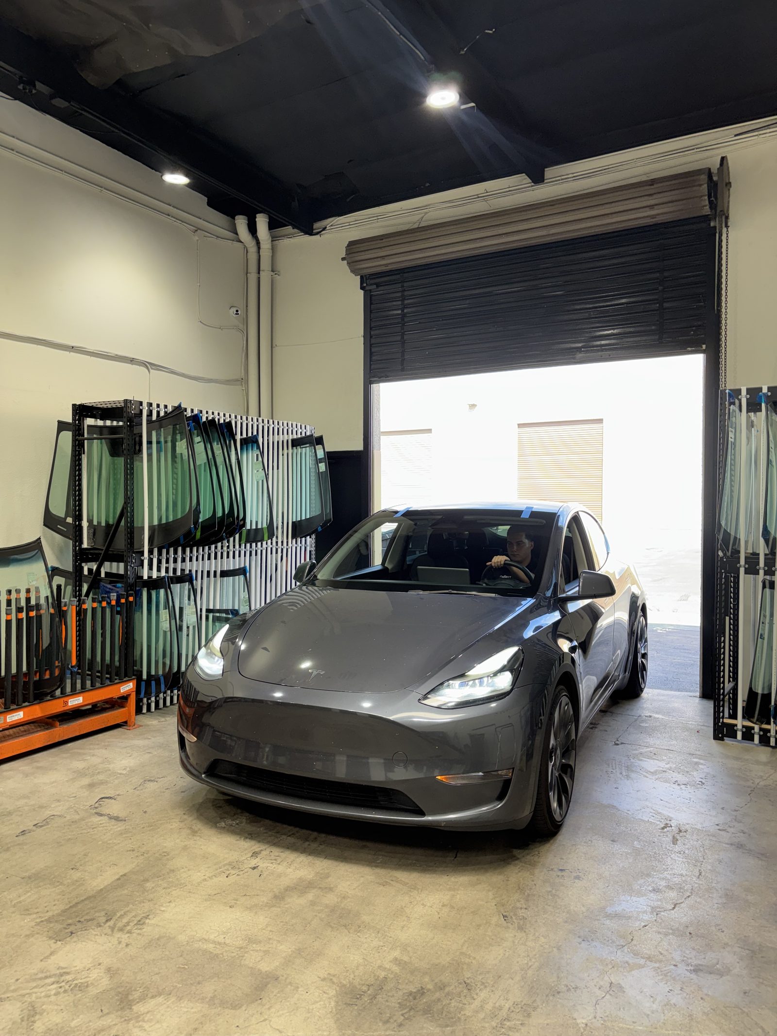A Tesla Model Y at the Connect Auto Glass shop door